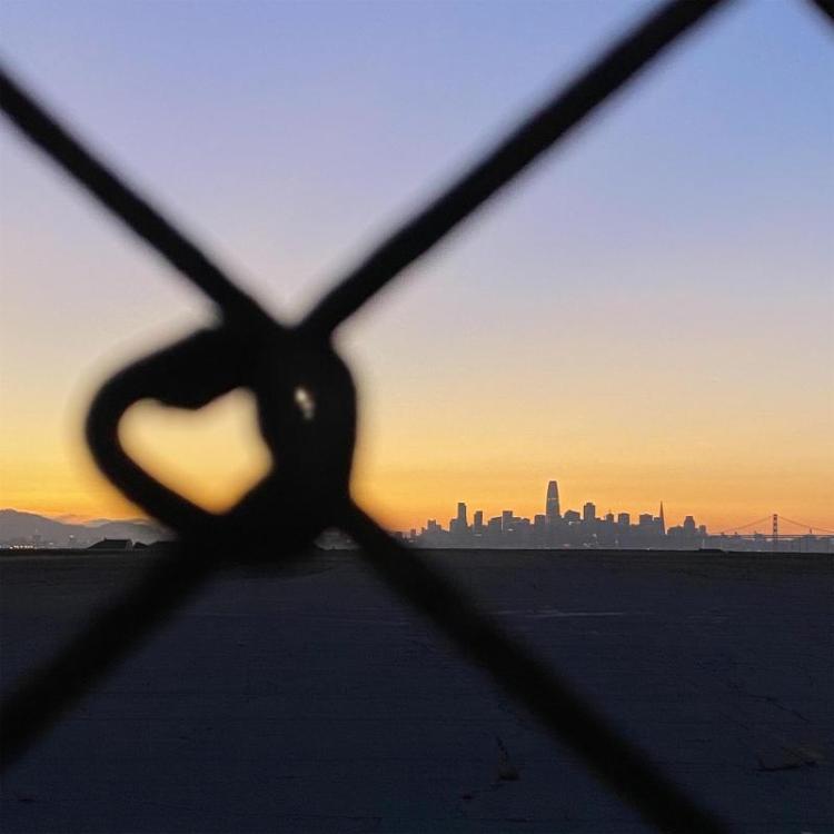 TahtinenRo-Chainlink-Fence-over-City-Skyline-Photo_12x12